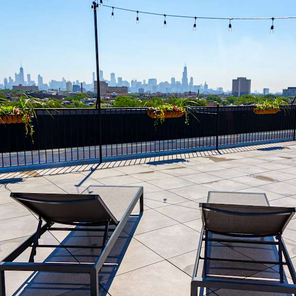 a patio roofdeck with lounge chairs and a view 