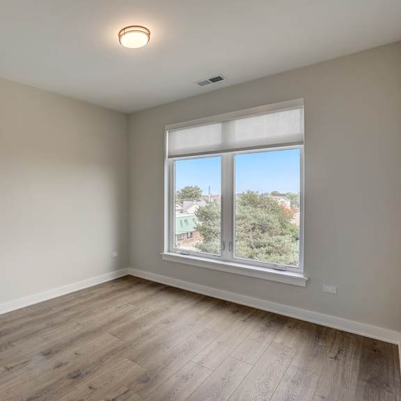 an empty room with wood floors and a window