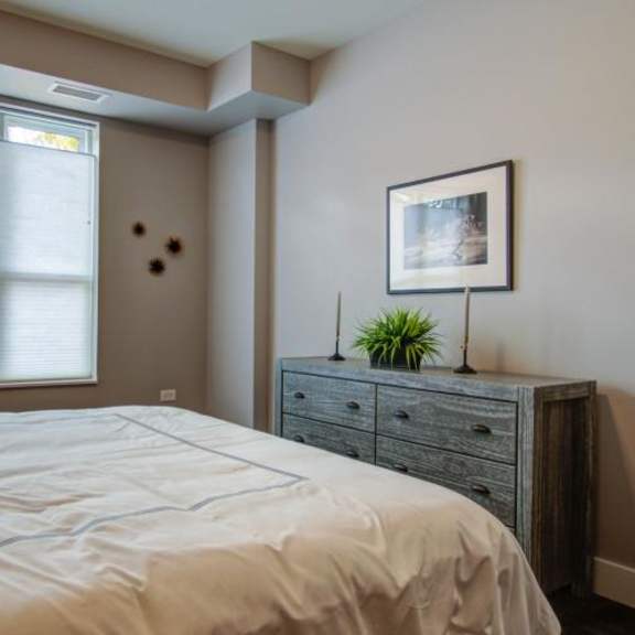 a bedroom with a bed and a dresser and a window at barrington 101, barrington illinois