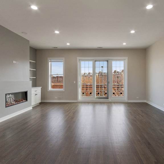 an empty living room with a fireplace and a window