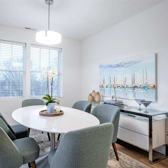 a dining room with a white table and chairs