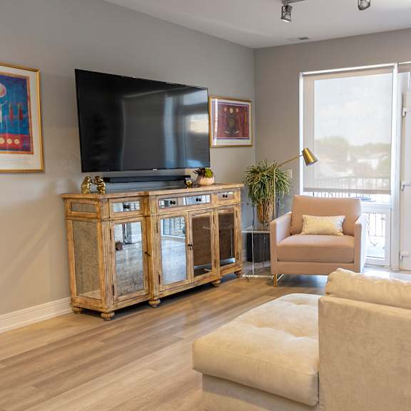 a living room with a couch and a tv and a balcony