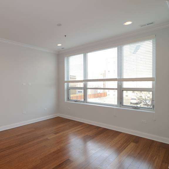 a living room with wood floors and a large window