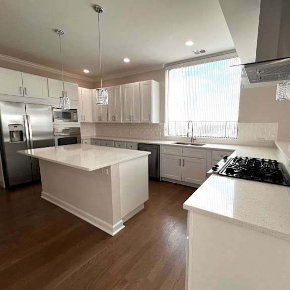 a kitchen with white counter tops and stainless steel appliances