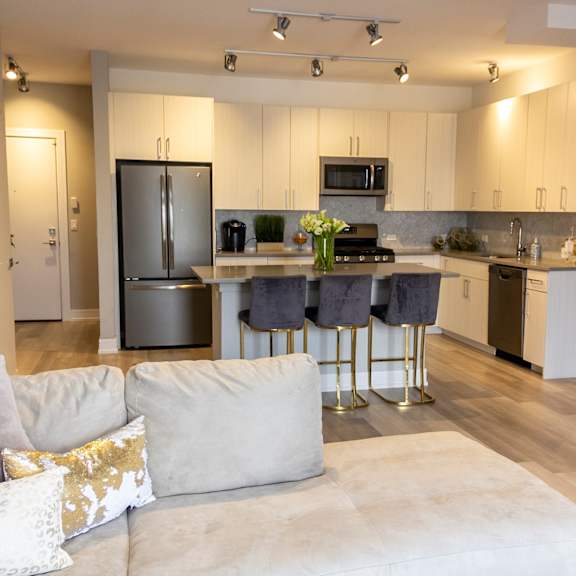 a kitchen with stainless steel appliances and a living room with a couch