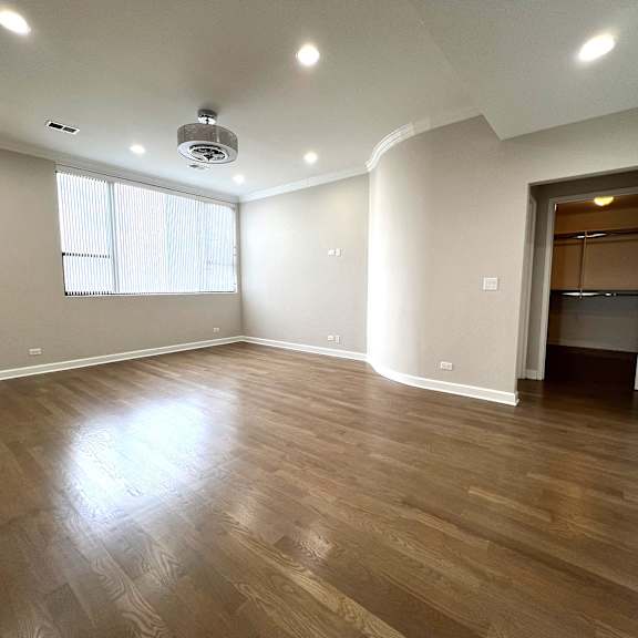 an empty living room with hardwood floors and a window