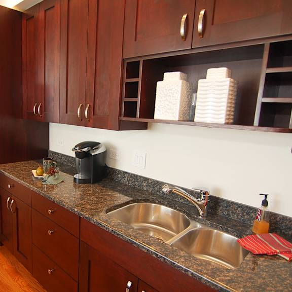 a kitchen with a granite counter top and a stainless steel refrigerator