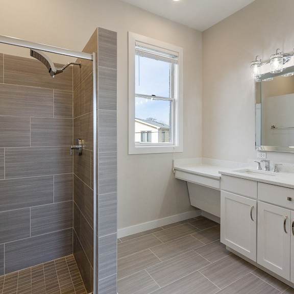 a bathroom with a shower and two sinks and a mirror