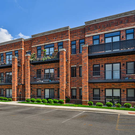 a row of red brick apartment buildings with balconies and windows.