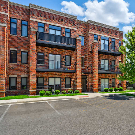 a large brick building with a parking lot in front.