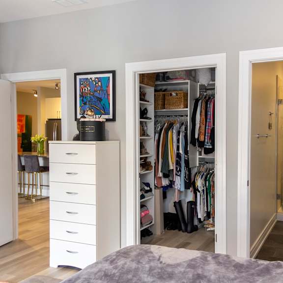 a bedroom with a closet and a bathroom with a shower