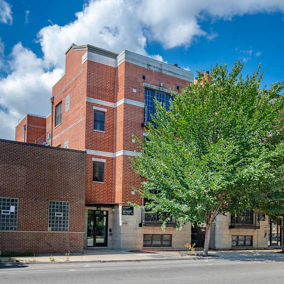 a large red brick building with a tree in front of it.