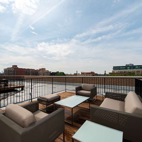 a rooftop deck with couches and tables overlooking a river and the city  at tripp 4321, chicago, il