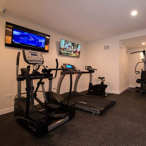 a home gym with exercise equipment and a tv