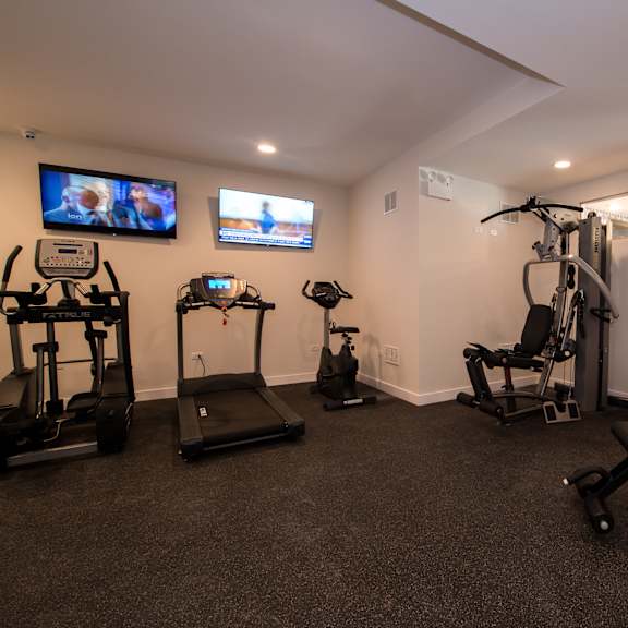 a home gym with exercise equipment and a tv