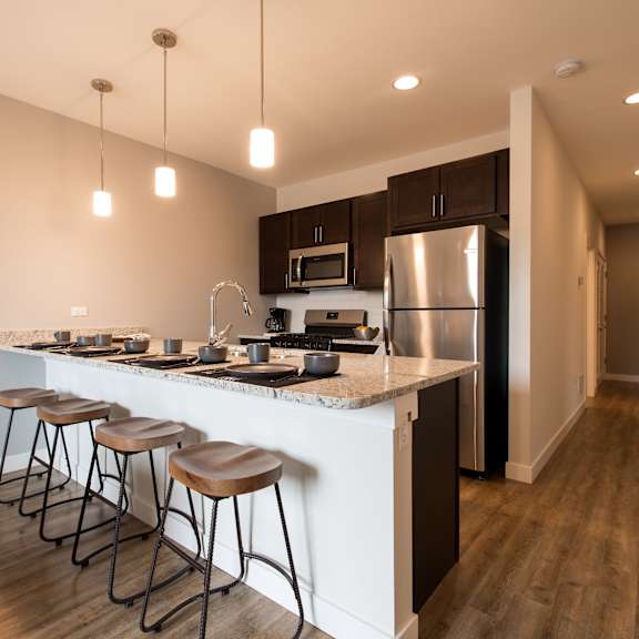 a kitchen with a large island with four stools