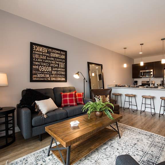 a living room with a couch and a table in front of a kitchen
