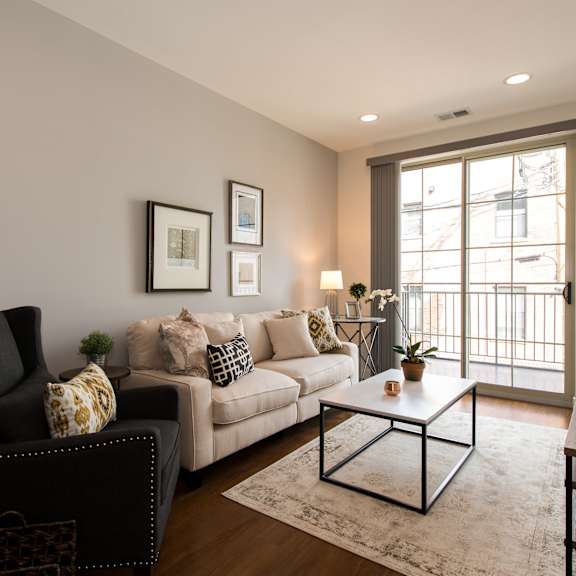a living room with a couch and a chair and a window