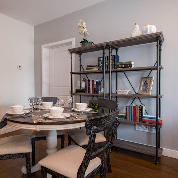 a dining room with a table and chairs and a bookshelf