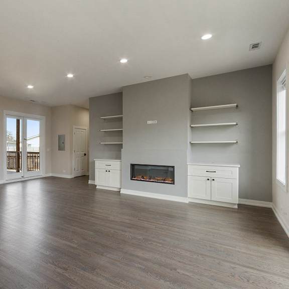 an open living room with a fireplace and a kitchen