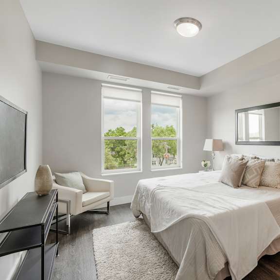 a white bedroom with a bed and a tv at barrington 101, illinois