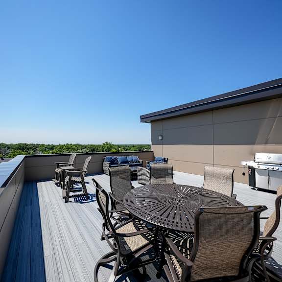 a patio with a table and chairs on a roof