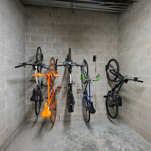 a group of bikes hanging on a wall in a storage room