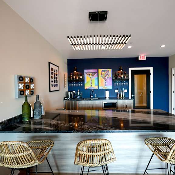 a bar with chairs and a blue wall in a room with a glass counter top