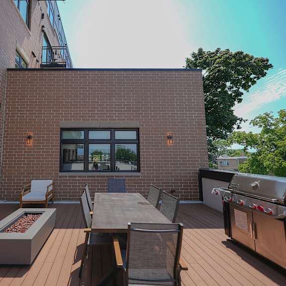 a backyard patio with a barbecue grill and a table and chairs