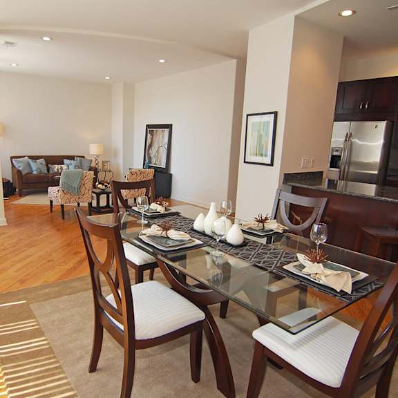 a dining room and living room with a glass table and chairs