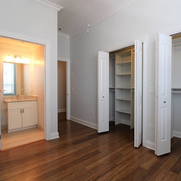 a bedroom with a closet and a sink and a mirror
