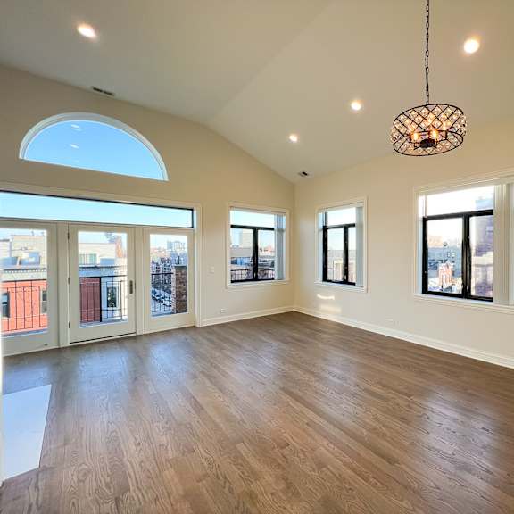 a large, empty room with wooden floors and a skylight.