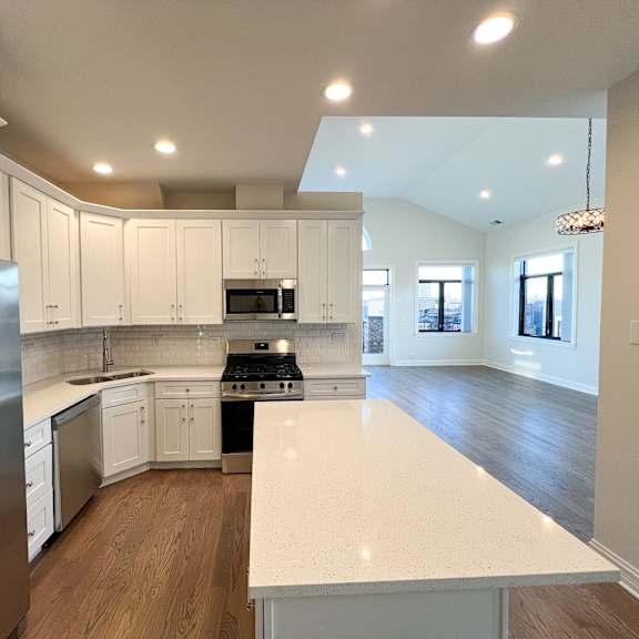 a modern kitchen with white cabinets and a stainless steel refrigerator.