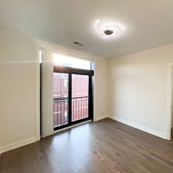 a room with a sliding glass door leading to a balcony.