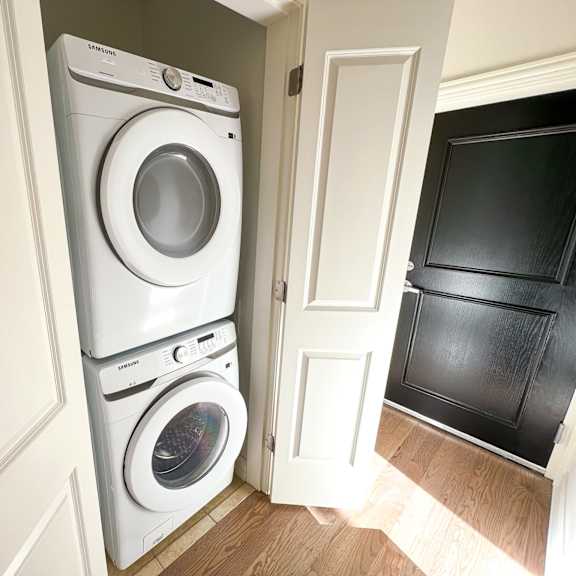 a white samsung washing machine and dryer in a small laundry room.