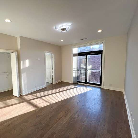a large empty room with wooden floors and white walls.