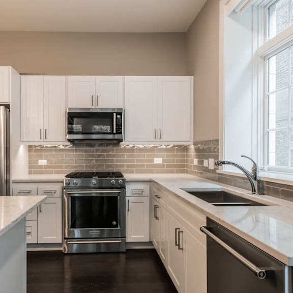 a kitchen with white cabinets and stainless steel appliances
