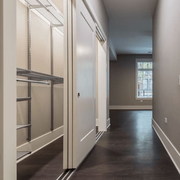a hallway with a closet and a sink and a mirror