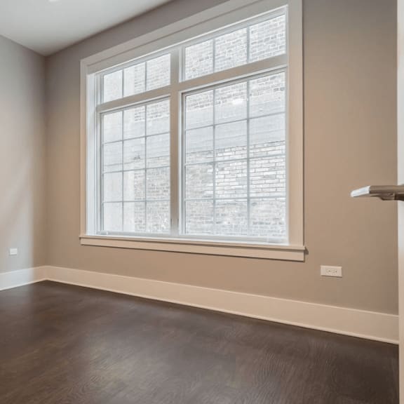 an empty room with wood floors and a window