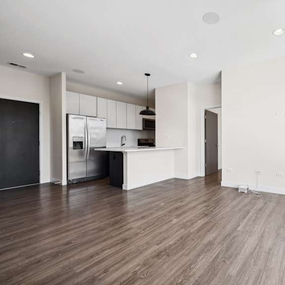 corner view of open-concept kitchen, dining, and living area at highpoint buena park on broadway featuring large windows, modern finishes, and seamless flow in a bright buena park apartment in chicago
