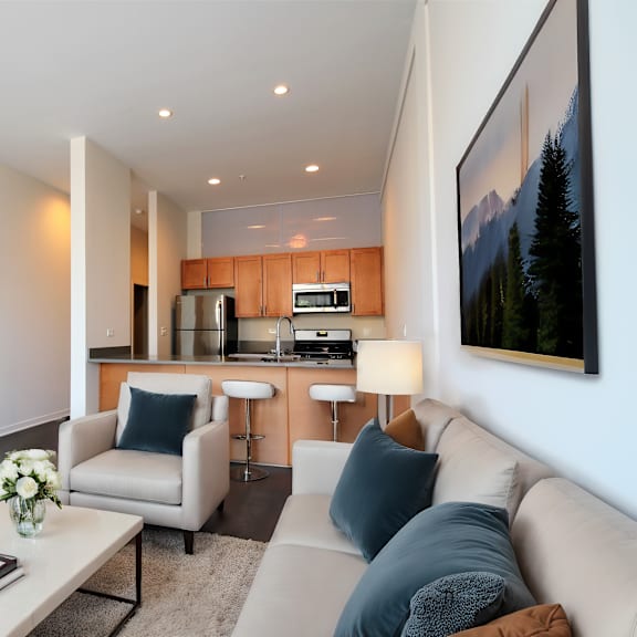 a living room and kitchen with a couch and a table