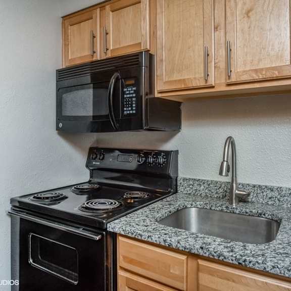 kitchen with black appliances and a built-in microwave at 1190 s bellaire st in denver, co
