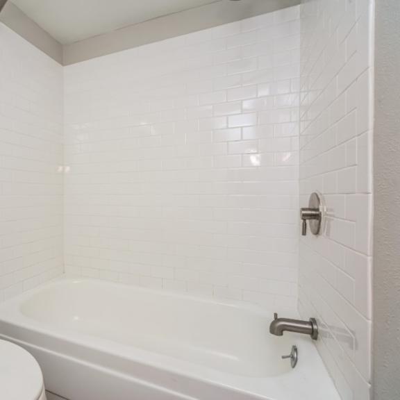 bright bathroom with tiled tub surround at 136 s penn in denver, co