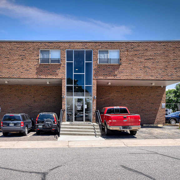 a red truck is parked in front of a brick building at 1190 s bellaire st in denver, co