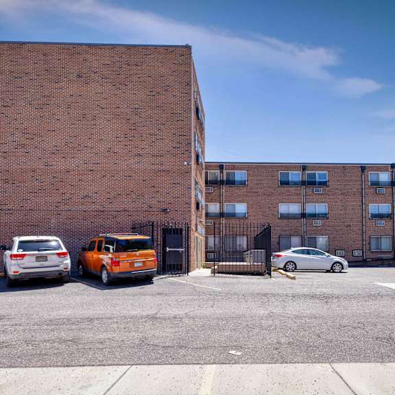 a parking lot with cars and a brick building at 1190 s bellaire st in denver, co