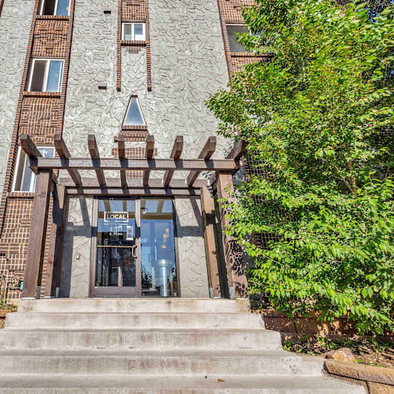 the front of a building with a stone facade and a wooden entrance at 136 s penn in denver, co