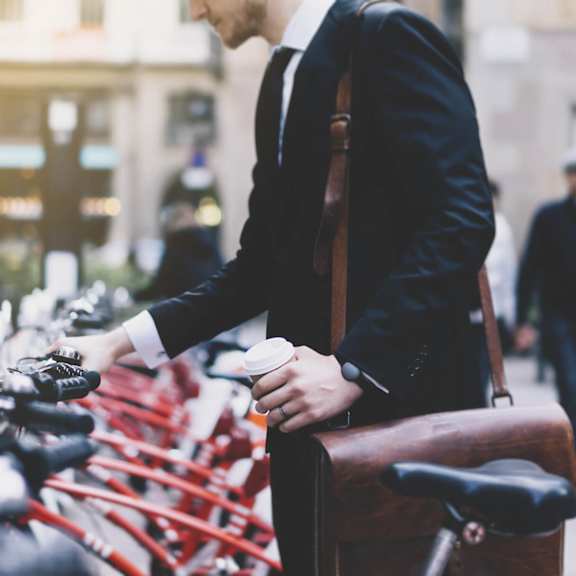 a man in a suit standing next to a row of bikes