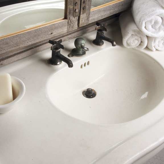 a bathroom sink with a bowl of soap and towels