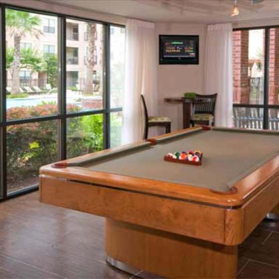 a pool table in a living room with sliding glass doors
