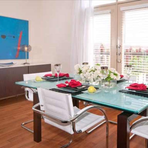 a room with a glass table and chairs in it
